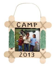 a wooden frame with the word camp on it and two children holding fishing rods in front of them