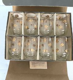 six glasses in a box with gold designs on the rims and bottom, all lined up