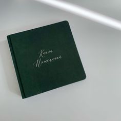 a close up of a book with writing on the front and back cover in white ink