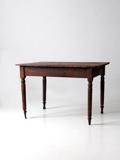 an old wooden table sitting on top of a white floor