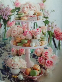 three tiered cake stand with pink flowers and macaroons