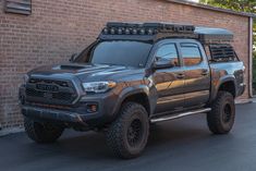 a gray truck parked in front of a brick building