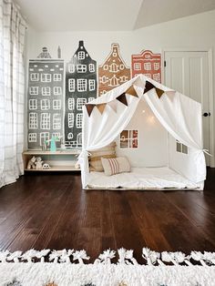 a child's bedroom with a white bed and wooden floors