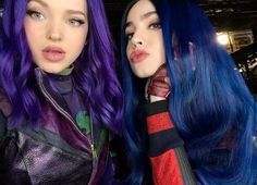 two women with blue and purple hair standing next to each other