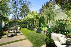 an outdoor patio with chairs and tables surrounded by greenery