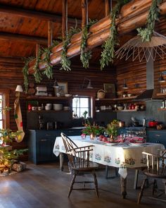 a kitchen with wooden walls and ceiling decorated for christmas