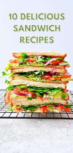 a stack of sandwiches with lettuce, tomato and other vegetables on top of it