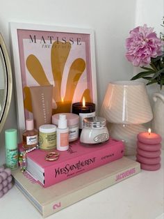 a table topped with books and candles next to a mirror