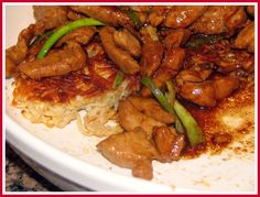 a white plate topped with meat and rice