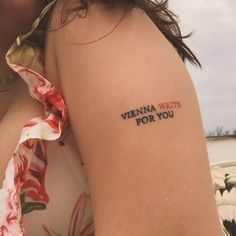 a woman with a tattoo on her arm that says vienna waits for you