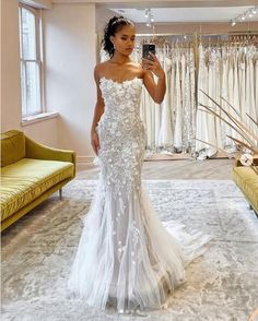 a woman is taking a selfie in her wedding dress at the bridal shop