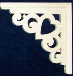 a wooden frame with hearts cut out of it on a blue velvet covered surface, ready to be used as a wall decoration