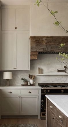 a kitchen with white cabinets and wood accents