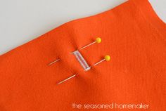 an orange piece of fabric with pins on it