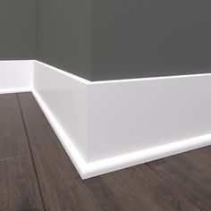 the corner of a room with wood floors and white trim on the walls is shown