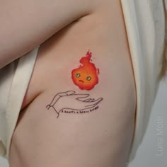 a woman's arm with a tattoo on it that has a hand holding an apple