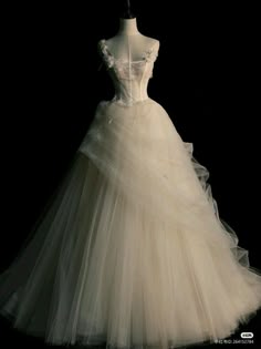 a white wedding dress on display in the dark