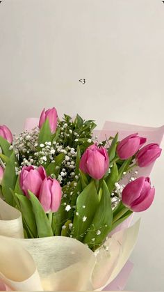 a bouquet of pink tulips with baby's breath