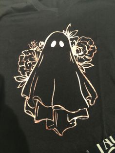 a black t - shirt with a ghost and flowers on it