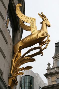 a gold sculpture on the side of a building