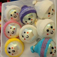 several snowman ornaments are in a plastic container