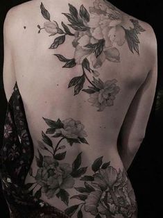 the back of a woman's body with flowers on her left shoulder and chest