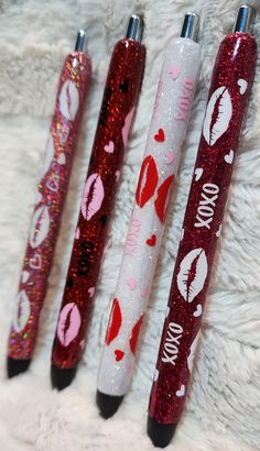 three glitter pens with lipstick on them sitting next to each other in front of a white furnishing