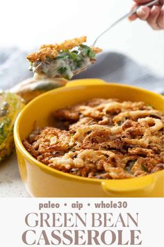 a yellow bowl filled with green bean casserole on top of a white table