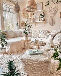 a living room filled with lots of furniture and plants on top of a white rug