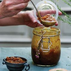 a person is spooning food out of a jar