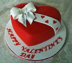 a red and white heart shaped cake sitting on top of a table