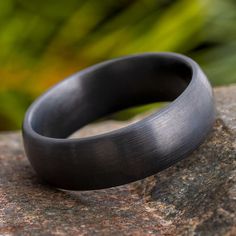 a black ring sitting on top of a rock