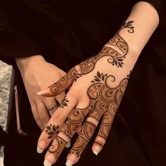 a woman's hand with henna tattoos on it