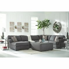 a living room filled with furniture and a large potted plant in the middle of the room