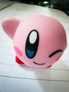 a pink toy sitting on top of a piece of paper