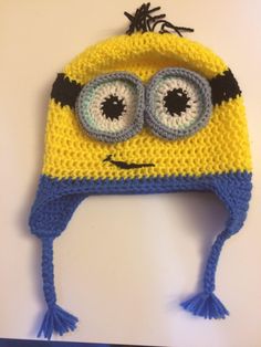 a crocheted yellow and blue hat with eyes