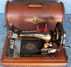 an old fashioned sewing machine sitting on top of a wooden stand next to a wall