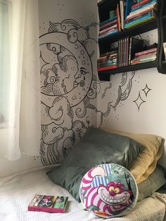 a bedroom with a bed, bookshelf and wall mural on the wall behind it