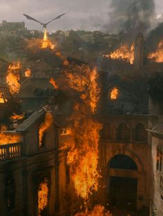 a large building on fire with birds flying over it