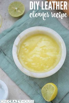 a white bowl filled with yellow liquid next to sliced lemons on a green napkin