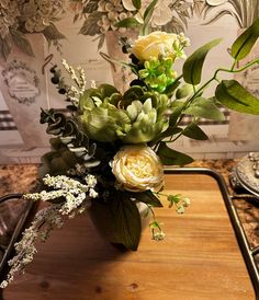 a vase filled with flowers sitting on top of a wooden table