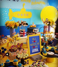 a yellow submarine themed birthday party with cupcakes and desserts on the table