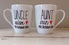 two white coffee mugs with the words uncle and annn written in black on them