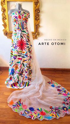 a dress on display in front of a gold framed mirror with the words arte otomii written below it