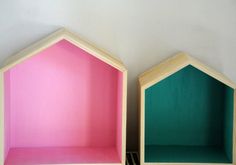 two wooden shelves sitting next to each other on top of a white wall with pink and green paint