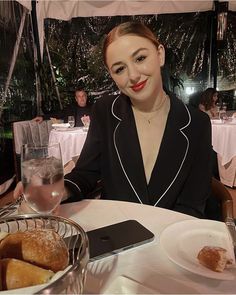 a woman sitting at a table with food in front of her