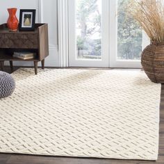 a white rug in a living room next to a table with vases on it