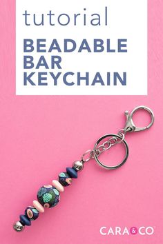 the beaded keychain is sitting on top of a pink surface with text overlay