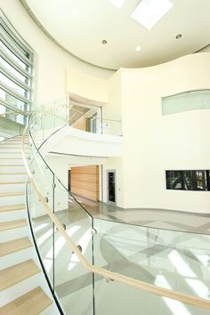 the inside of a house with stairs and glass railings