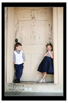 two young children standing in front of a door